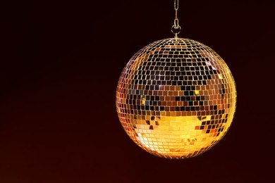 Photo of Shiny bright disco ball on color background, space for text