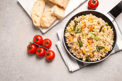Photo of Delicious rice pilaf with chicken and vegetables on light grey table, flat lay