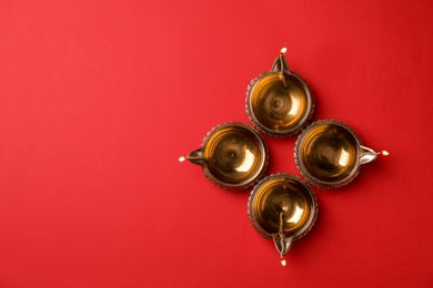 Photo of Diwali diyas or clay lamps on color background, top view