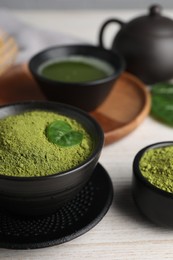 Photo of Green matcha powder on white wooden table, closeup