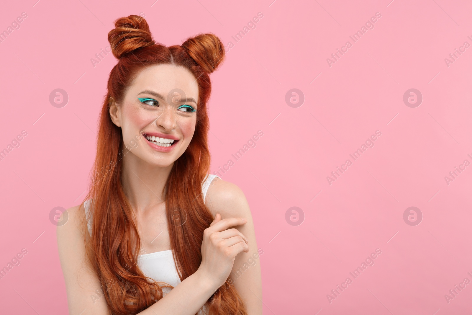 Photo of Happy woman with bright makeup on pink background. Space for text