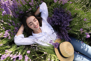 Young woman lying in lavender field on summer day