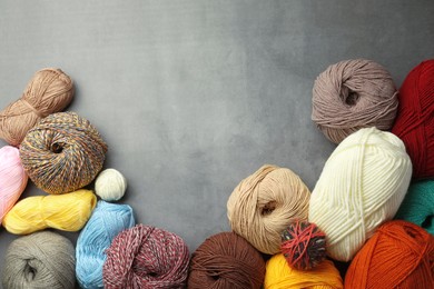 Photo of Different ballswoolen knitting yarns on grey background, flat lay. Space for text