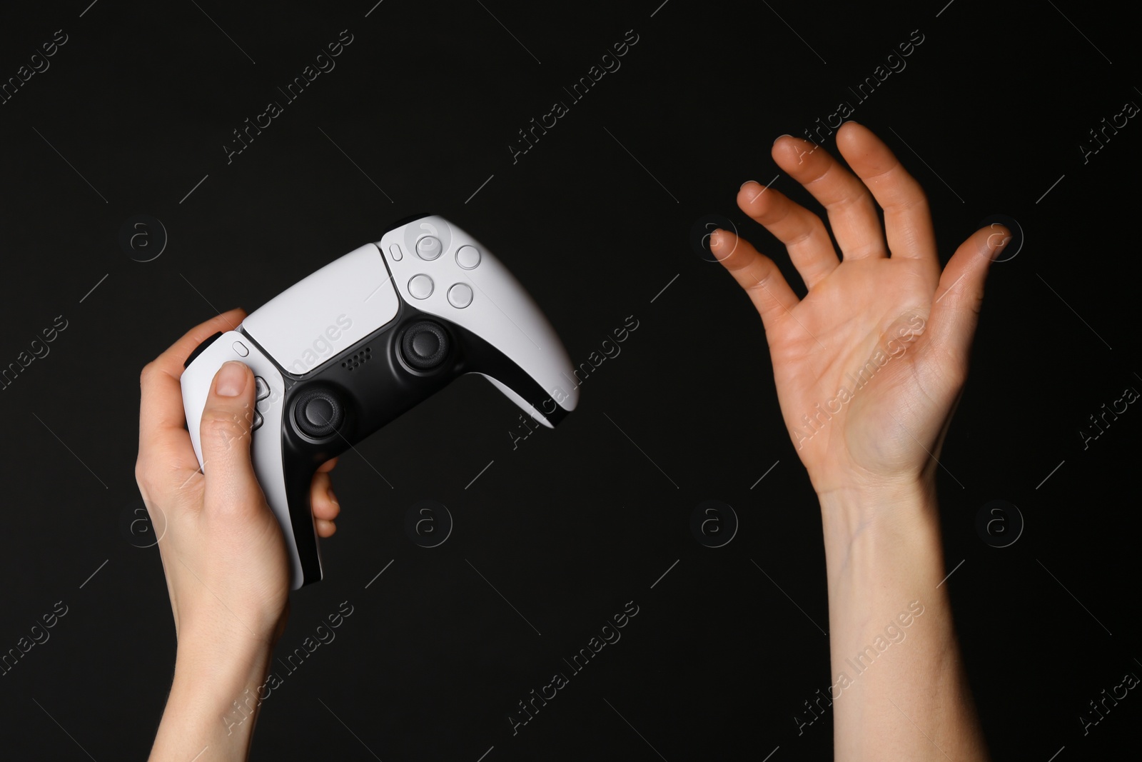 Photo of Woman with game controller on black background, closeup