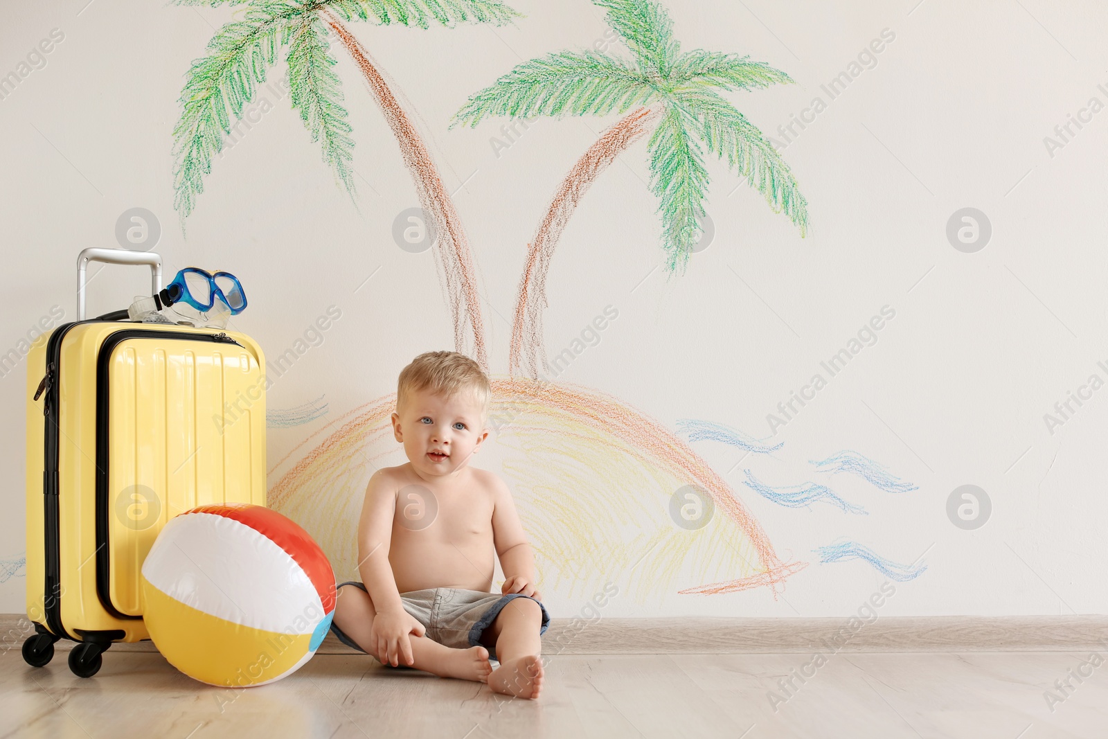 Photo of Adorable little child playing traveler with suitcase indoors