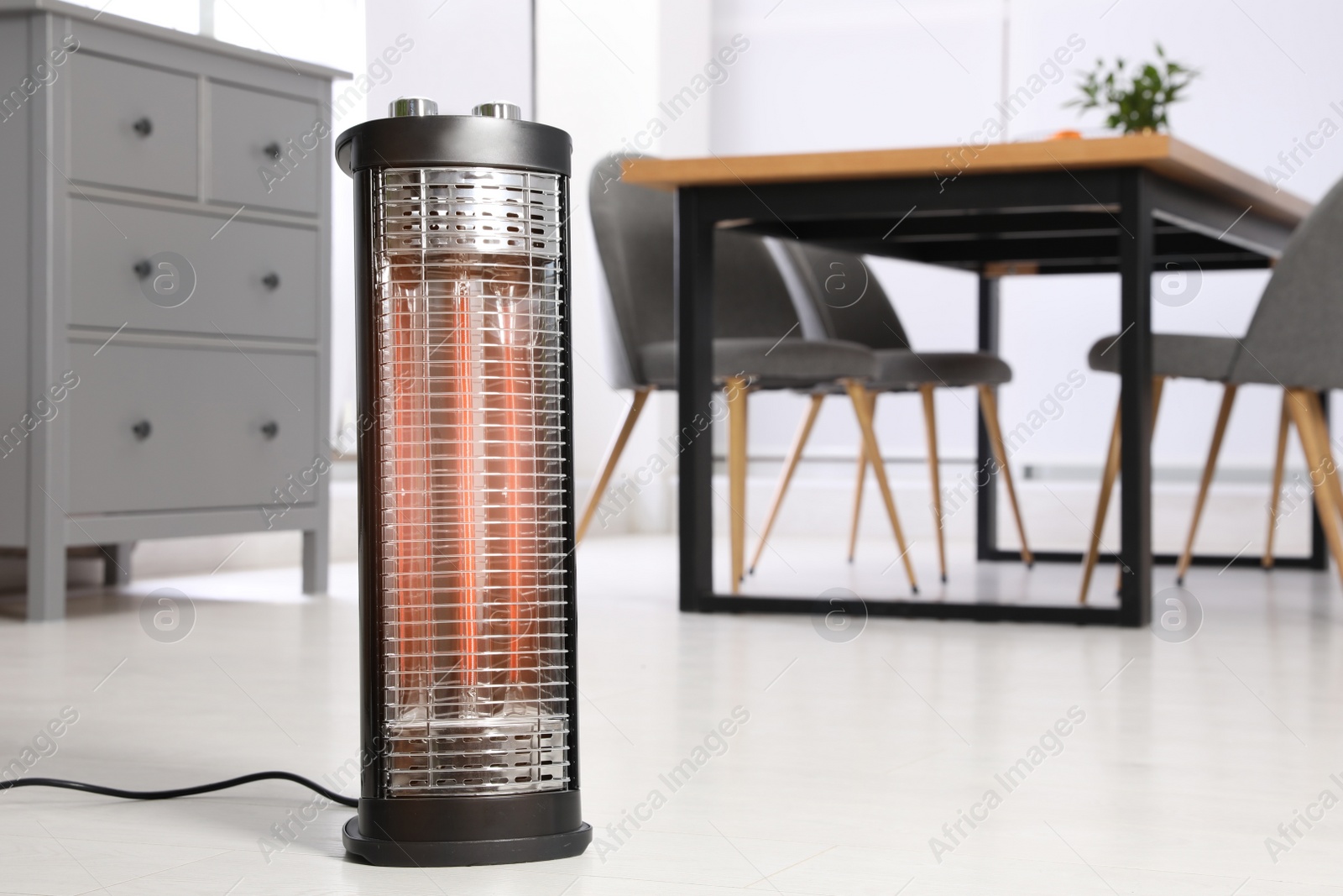 Photo of Modern electric heater on floor at home. Space for text