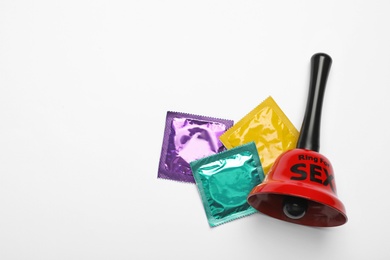 Sex bell and condoms on white background, top view