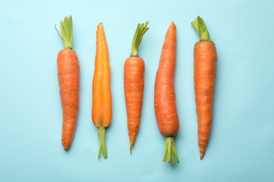 Flat lay composition with fresh carrots on color background