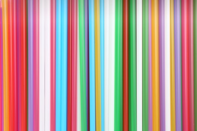 Heap of colorful plastic straws for drinks as background, closeup