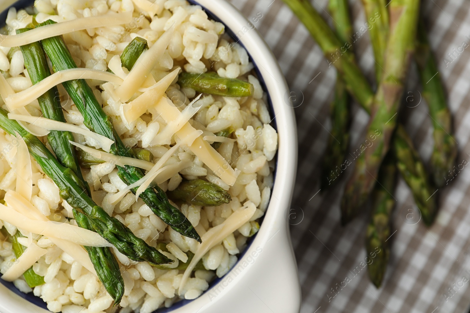 Photo of Delicious risotto with asparagus served on table, closeup