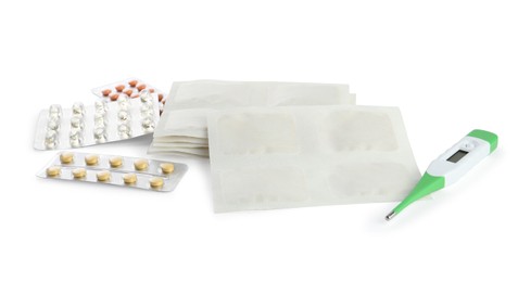 Mustard plasters, pills and thermometer on white background
