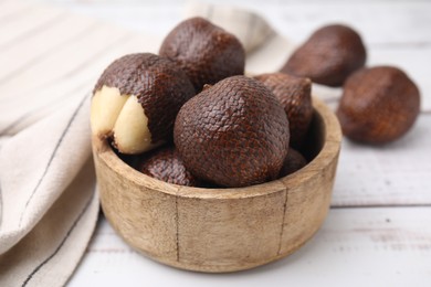 Photo of Fresh salak fruits in bowl on white wooden table, closeup