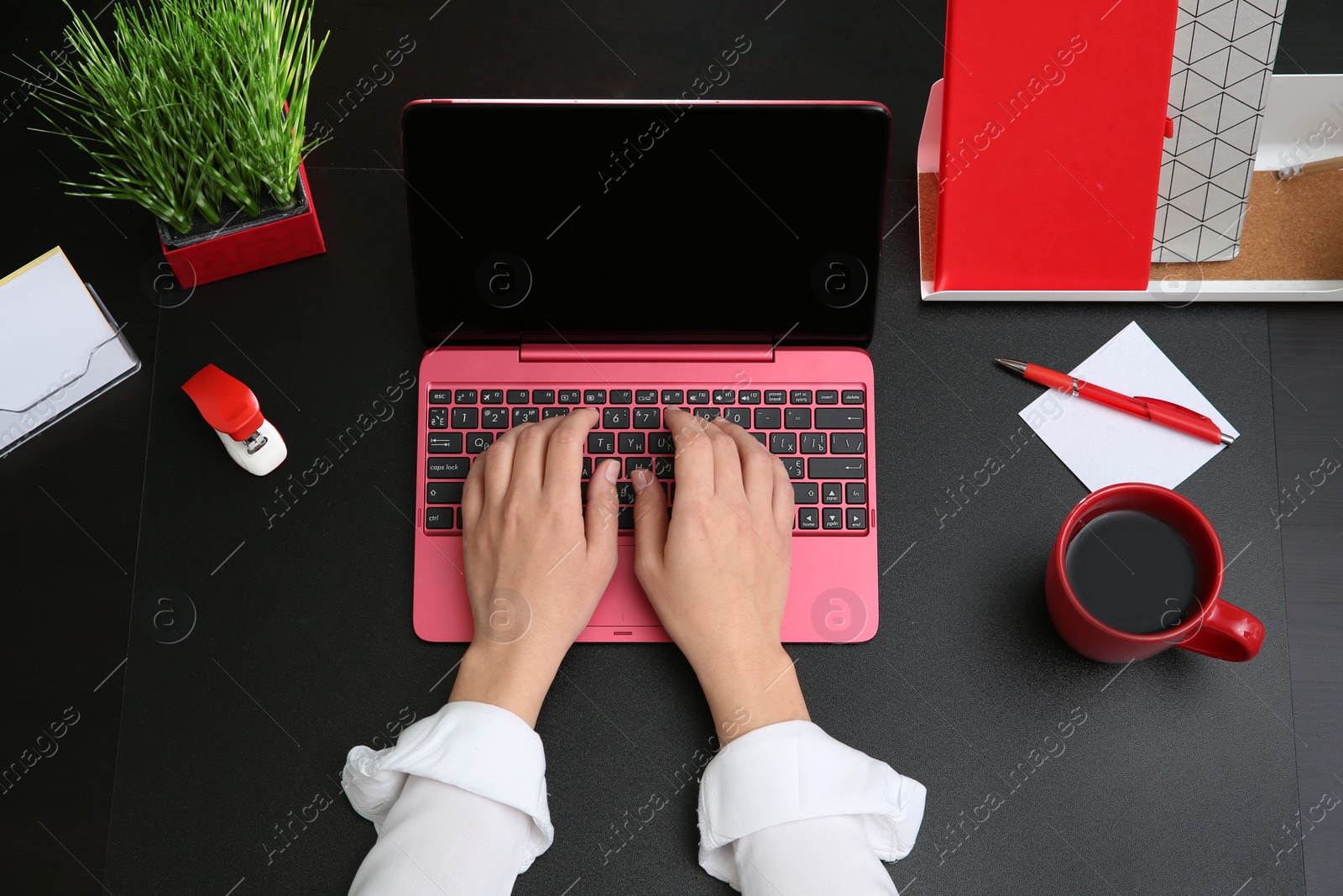 Photo of Woman using modern laptop at table, top view