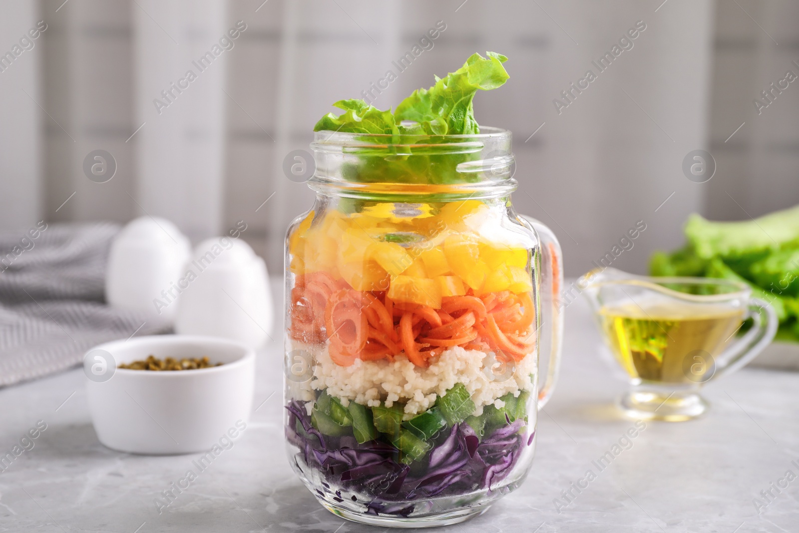 Photo of Healthy salad in glass jar on marble table