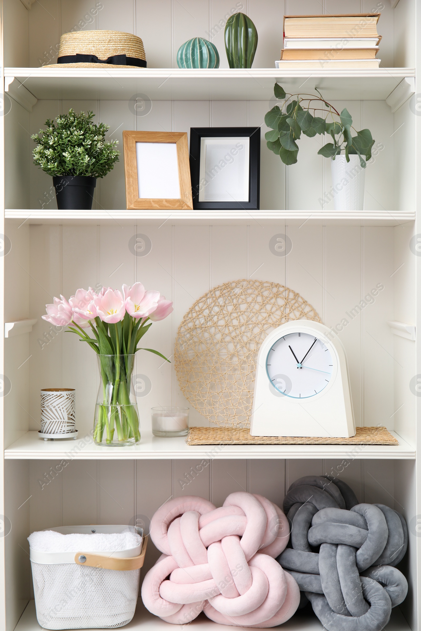 Photo of White shelving unit with plants and different decorative stuff