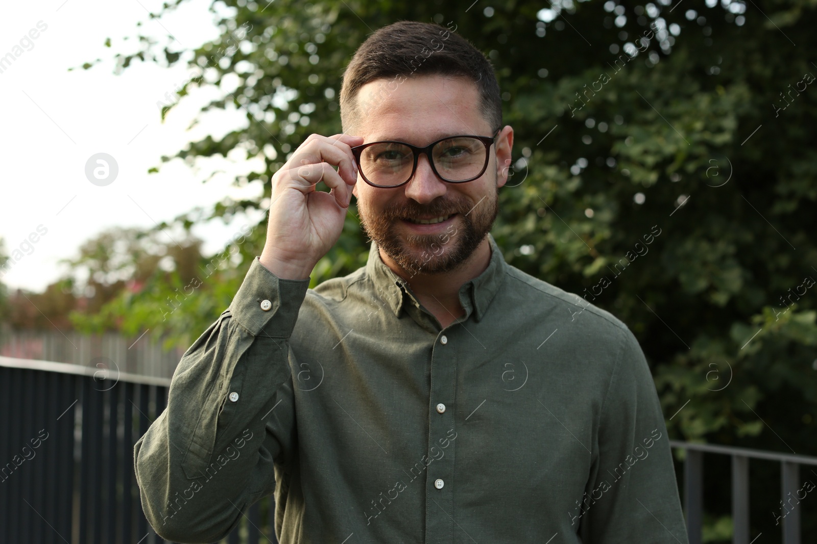 Photo of Portrait of handsome bearded man in glasses outdoors