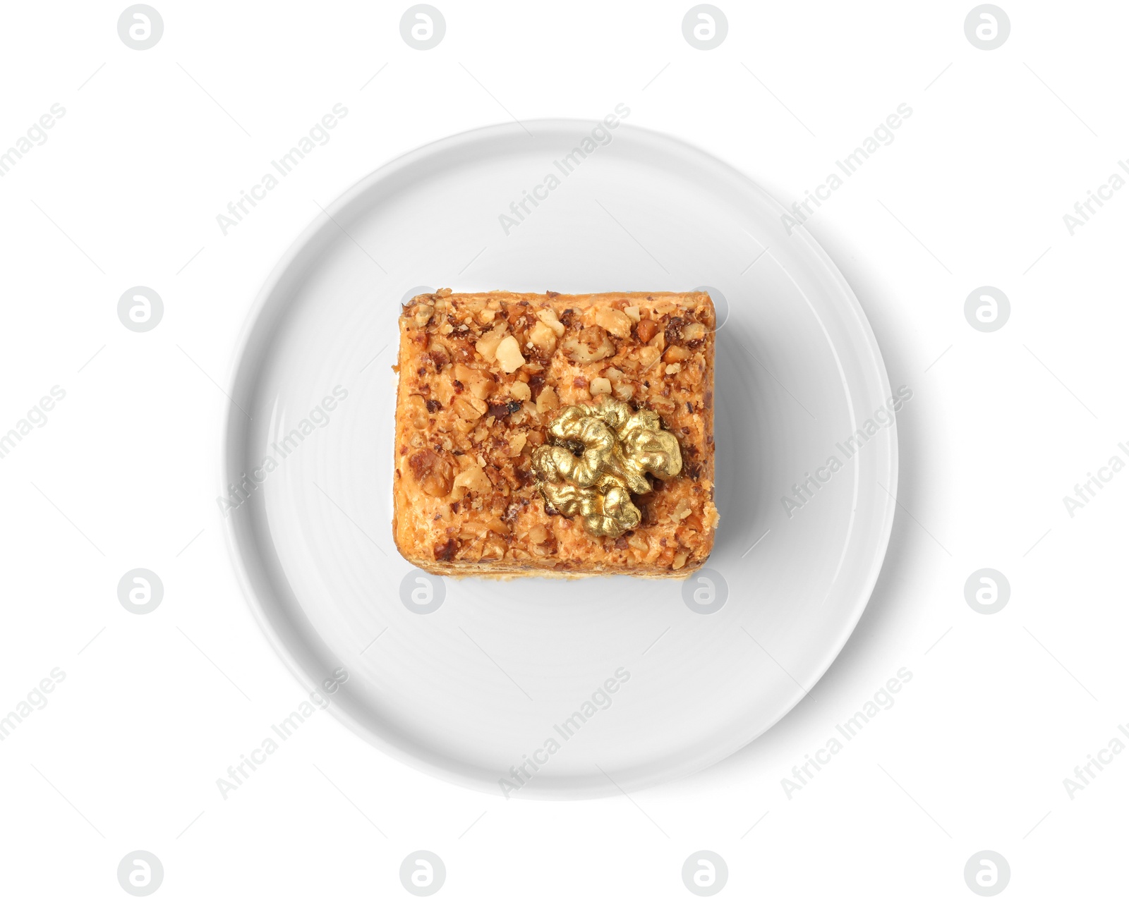 Photo of Piece of layered honey cake with walnuts on white background, top view