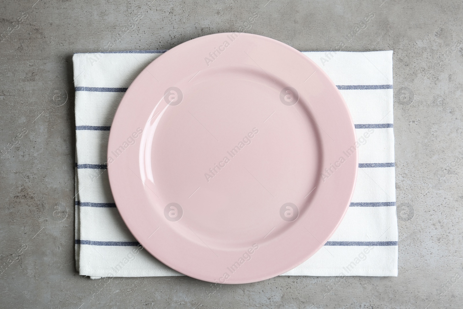 Photo of Empty plate and napkin on grey table, top view