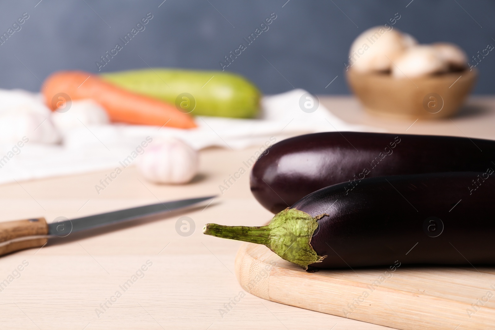 Photo of Fresh eggplants on wooden table, closeup. Space for text