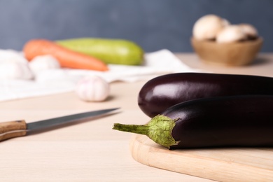 Photo of Fresh eggplants on wooden table, closeup. Space for text