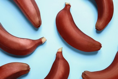 Tasty red baby bananas on light blue background, flat lay