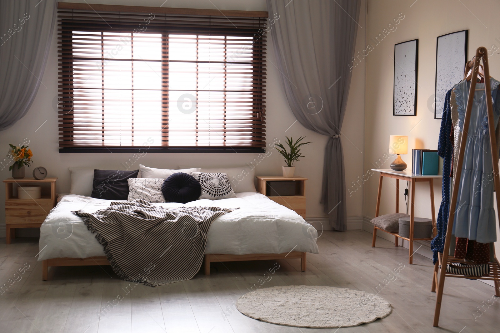 Photo of Modern room interior with comfortable double bed and window blinds