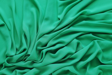 Photo of Beautiful green tulle fabric as background, top view
