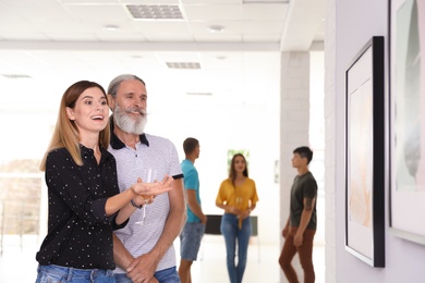 Senior man and woman at exhibition in art gallery