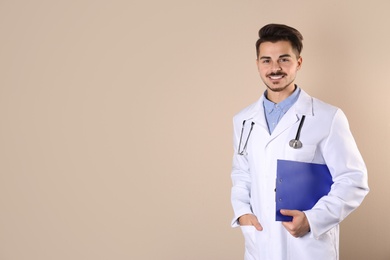 Young medical student with clipboard on color background. Space for text