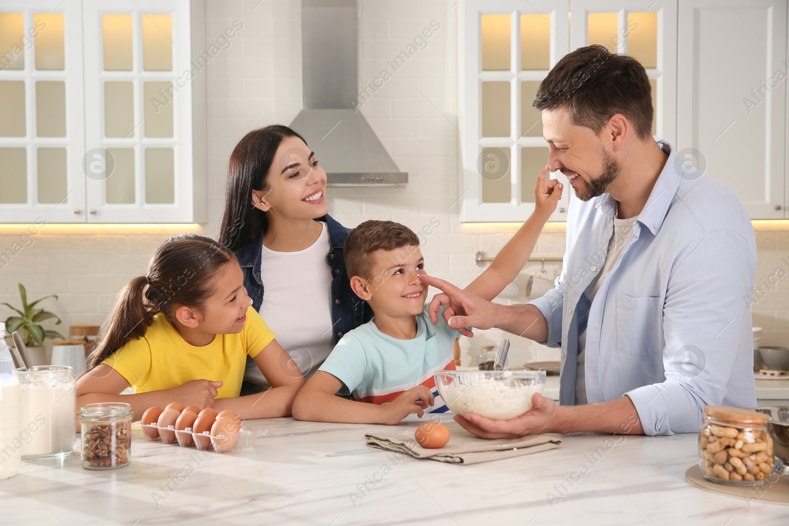 Photo of Happy family cooking together at table in kitchen. Adoption concept