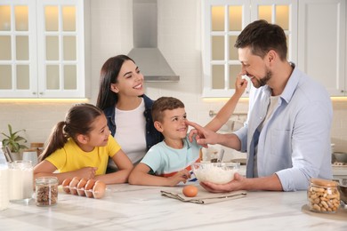 Photo of Happy family cooking together at table in kitchen. Adoption concept