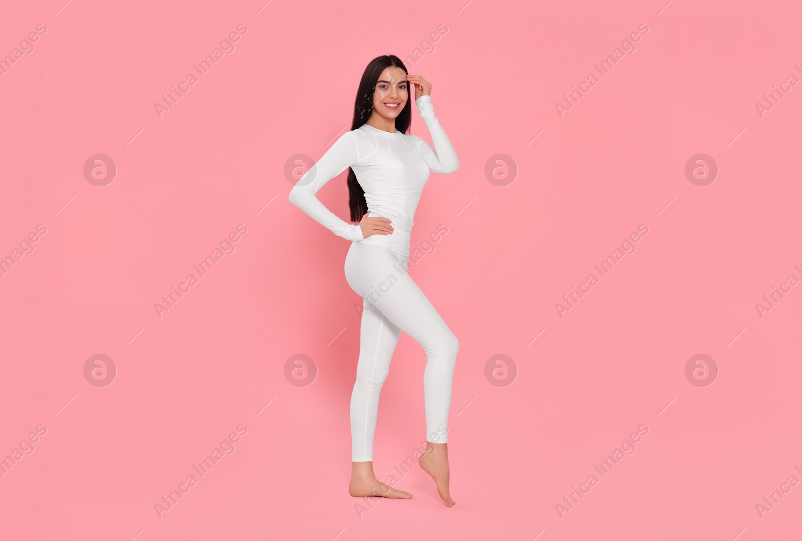 Photo of Woman in warm thermal underwear on pink background. Space for text