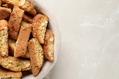 Photo of Traditional Italian almond biscuits (Cantucci) on light marble table, top view. Space for text