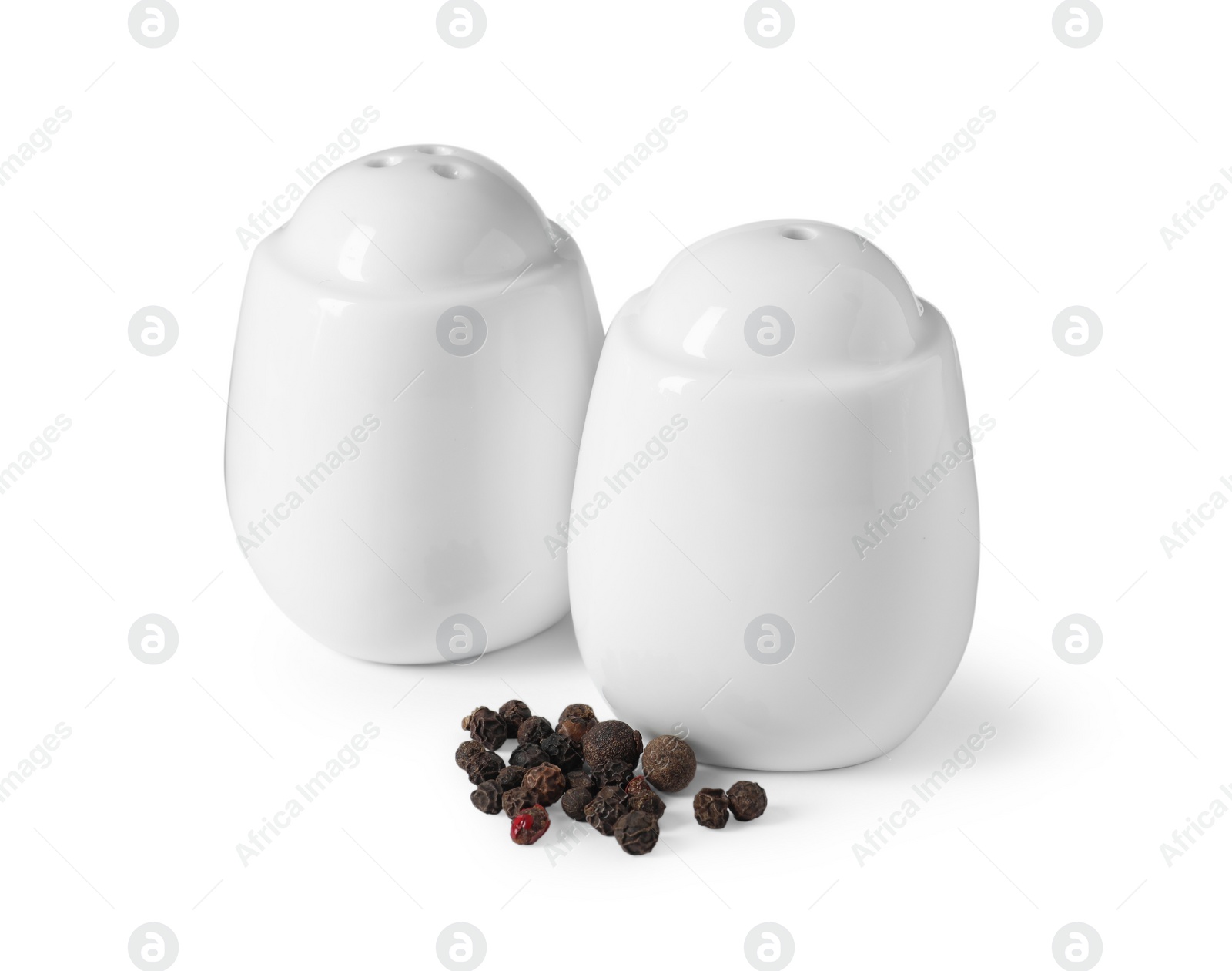 Photo of Salt and pepper shakers with grains isolated on white