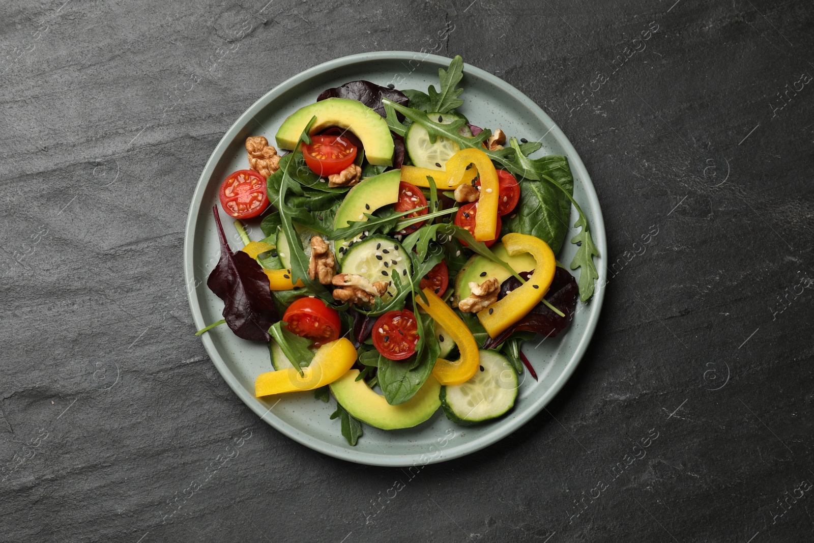 Photo of Balanced diet and vegetarian foods. Plate with different delicious products on black table, top view