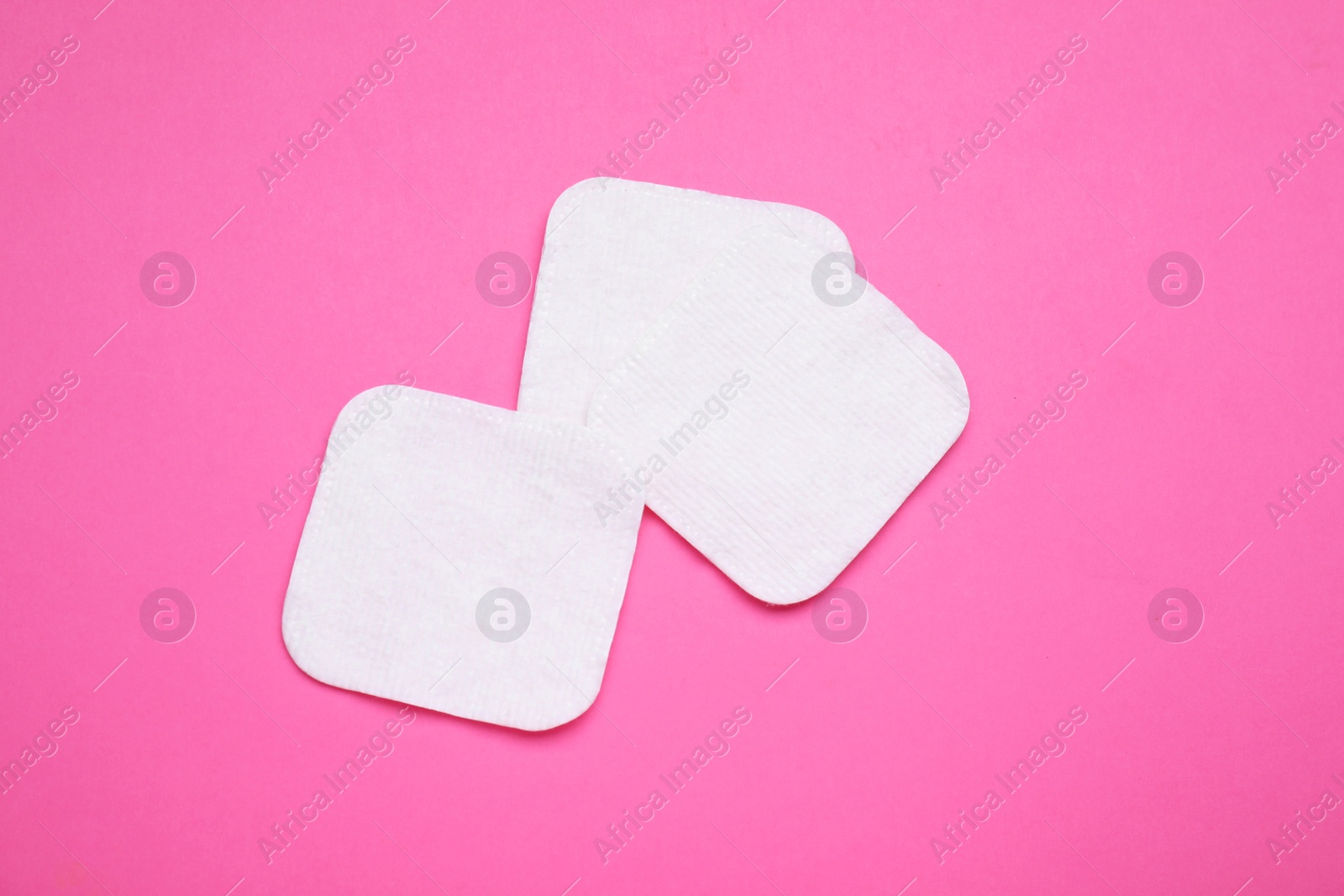 Photo of Cotton pads on pink background, flat lay