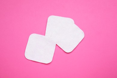 Photo of Cotton pads on pink background, flat lay
