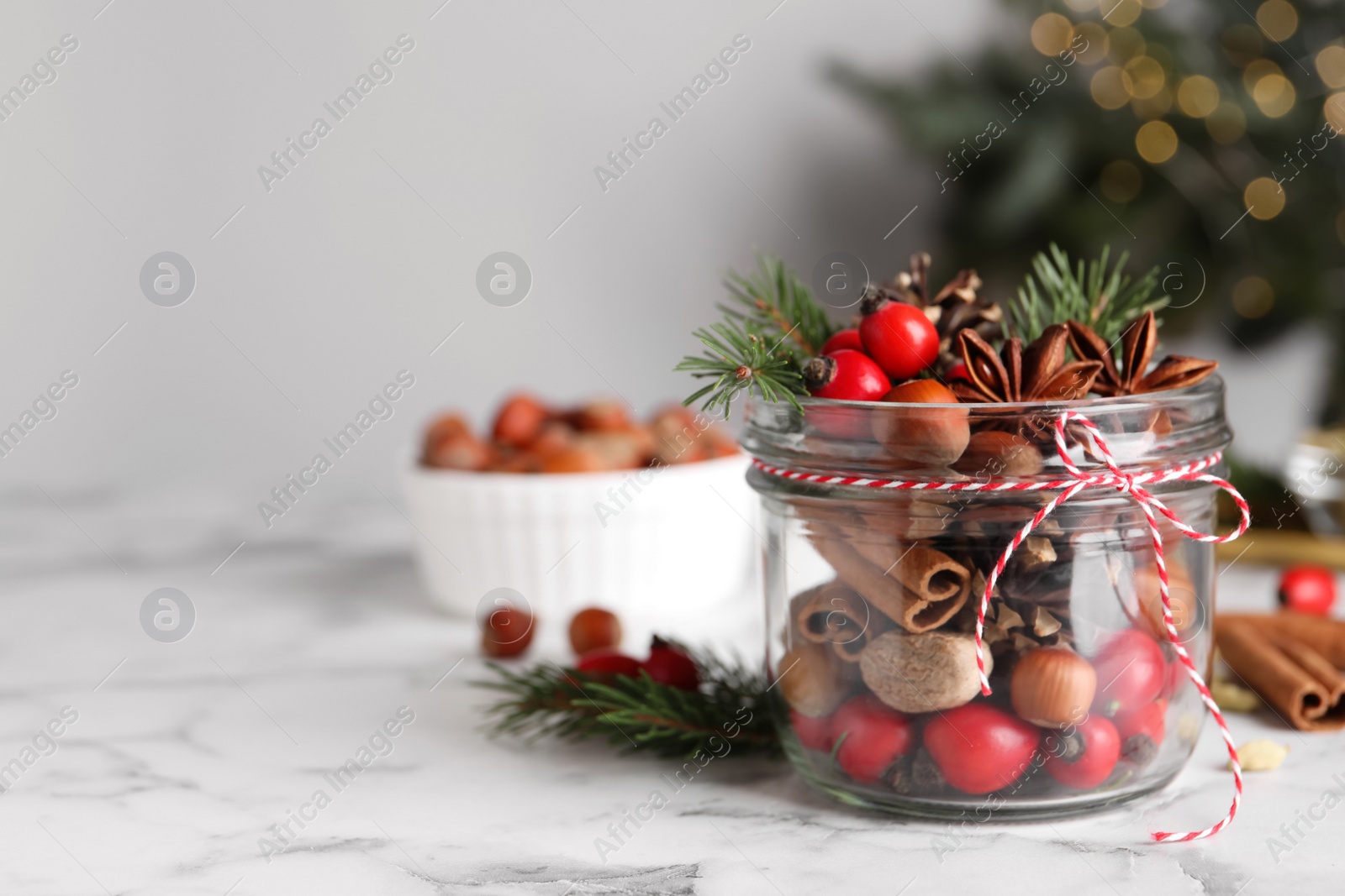 Photo of Aromatic potpourri in glass jar on white table. Space for text