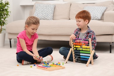Photo of Children playing with different math game kits on floor in living room. Study mathematics with pleasure