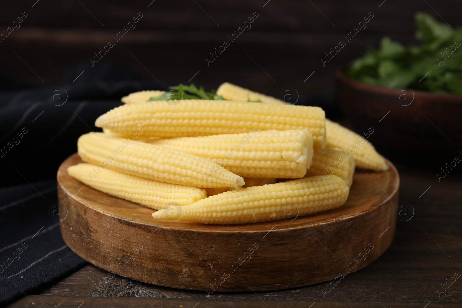 Photo of Tasty fresh yellow baby corns on wooden table