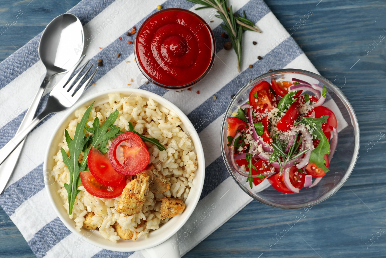 Photo of Delicious chicken risotto served on blue wooden table, flat lay