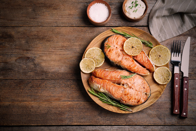 Flat lay composition with cooked red fish on wooden table, space for text. Food photography  