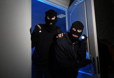 Thieves with flashlights breaking into house at night