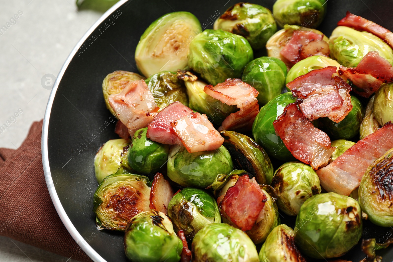 Photo of Delicious Brussels sprouts with bacon in pan, closeup