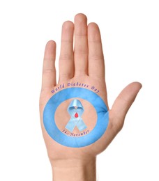 Image of Man showing blue circle, awareness ribbon with paper blood drop as World Diabetes Day symbol on palm against white background, closeup of hand
