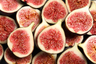 Halves of fresh ripe figs on table, top view