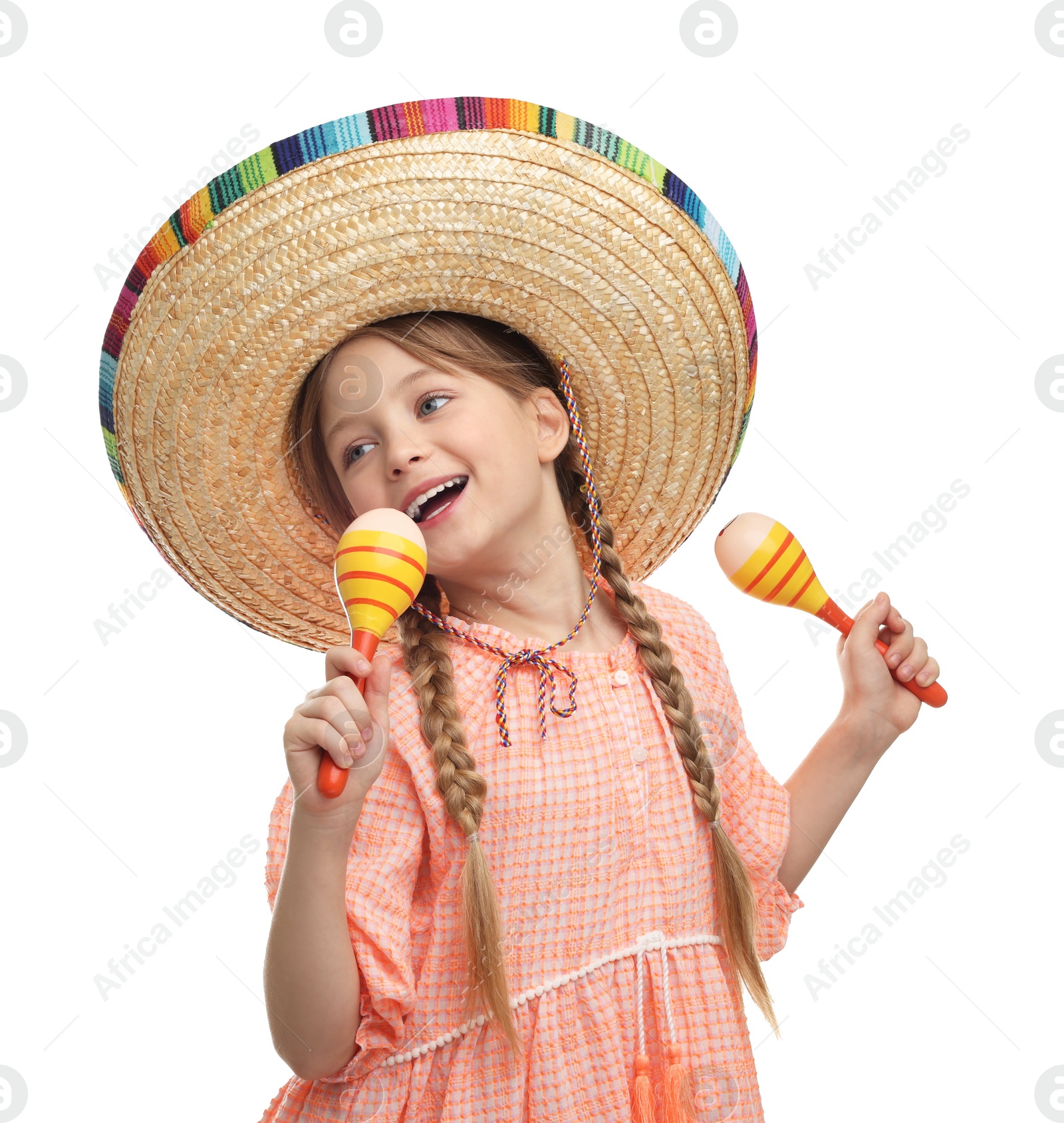 Photo of Cute girl in Mexican sombrero hat singing with maracas on white background