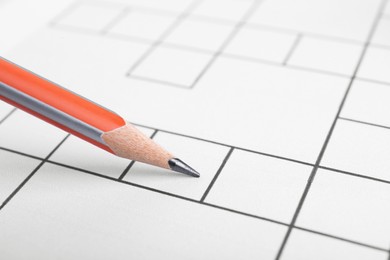 Photo of Pencil and blank crossword, closeup view. Space for text