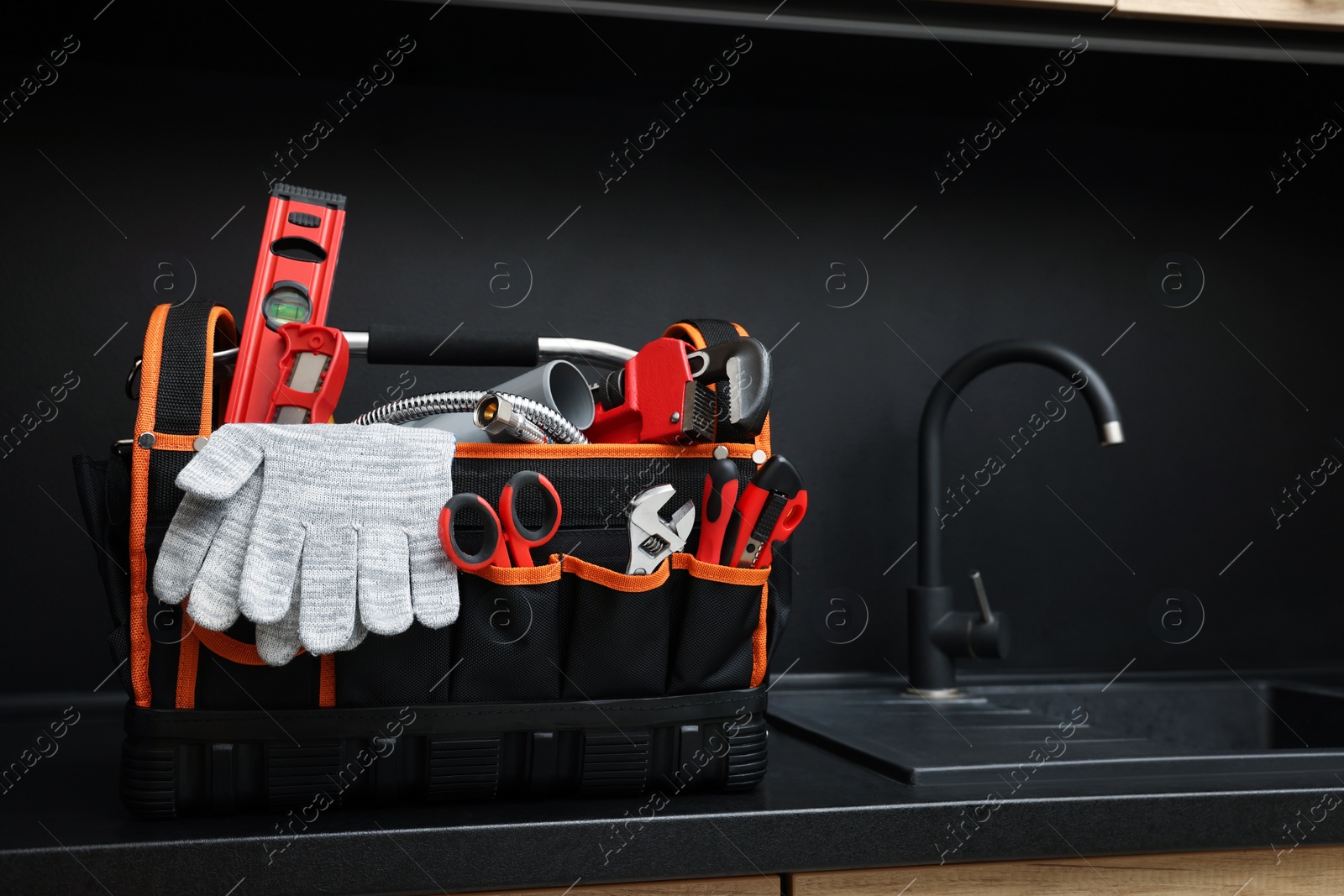 Photo of Plumber's tool bag on kitchen counter near sink