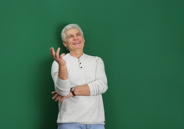 Photo of Portrait of handsome mature man on color background